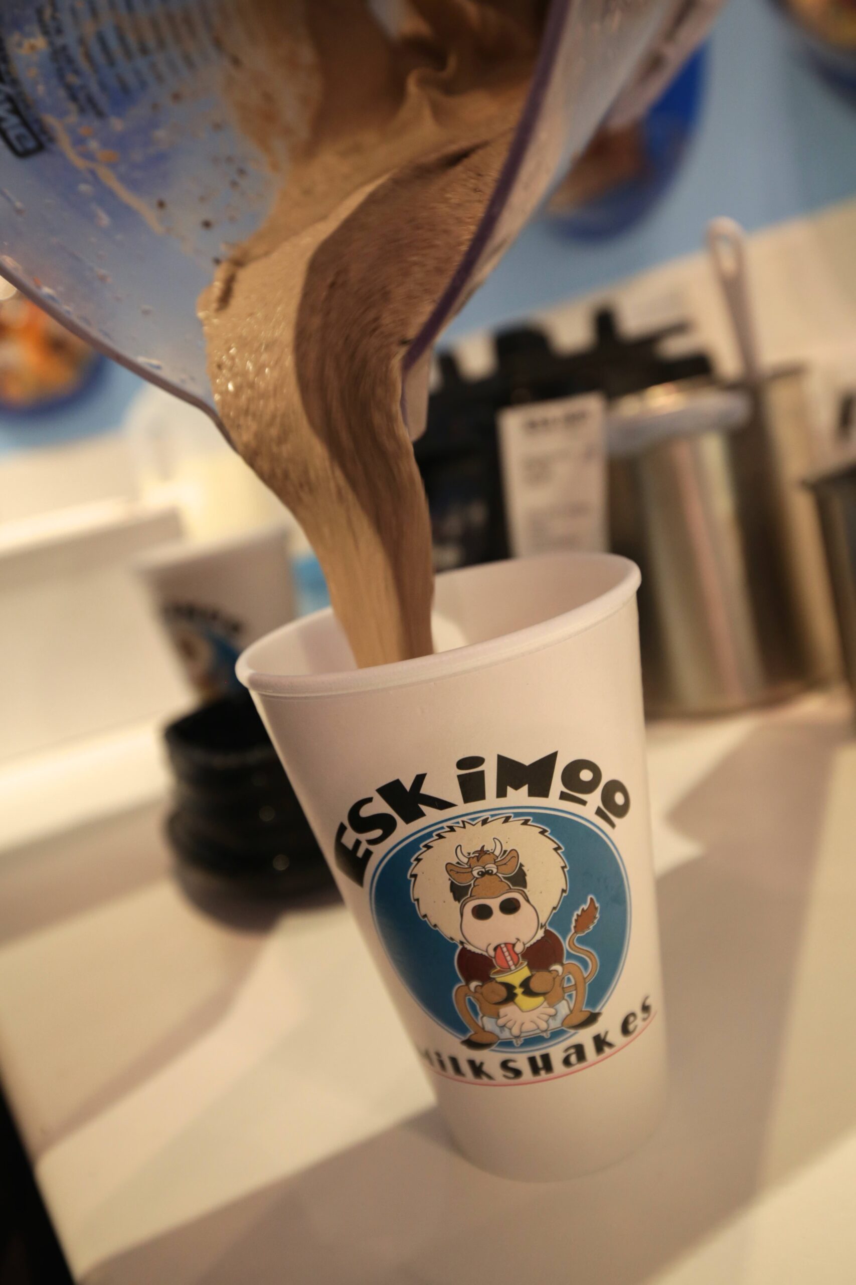 Eskimoo chocolate milkshake being poured into a cup